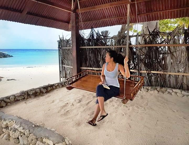 Girl on a swing looking out to sea