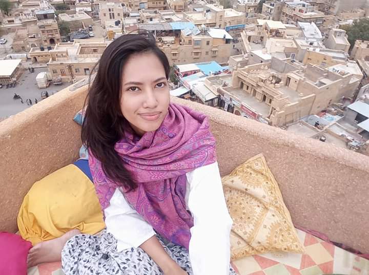 girl sitting on balcony overlooking Jaisalmer city