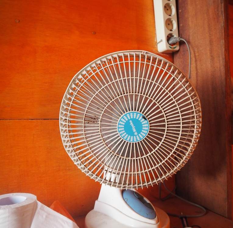 Table fan on a table with orange background